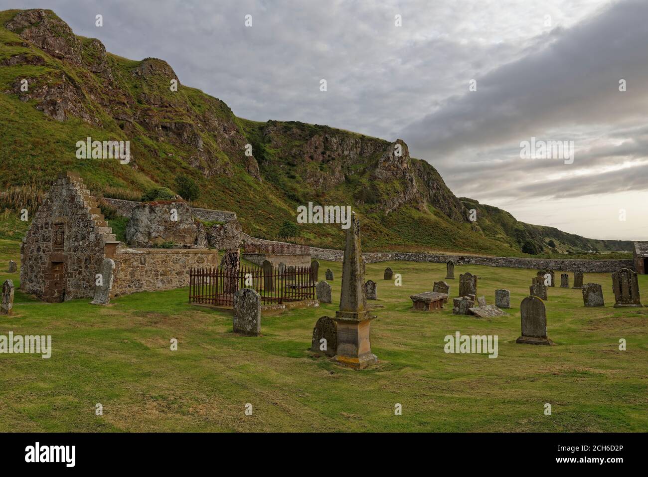 Die Nether Kirkyard Begräbnisstätte am Fuße der dramatischen Klippen im St Cyrus National Nature Reserve, mit seinen alten Grabsteinen und Begräbnis enc Stockfoto