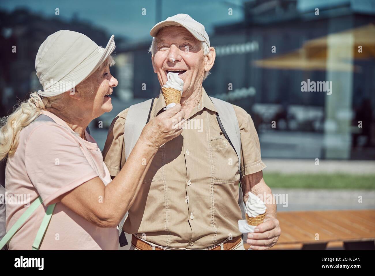 Zufriedener Mann, der Dessert aus der Hand seiner Frau isst Stockfoto