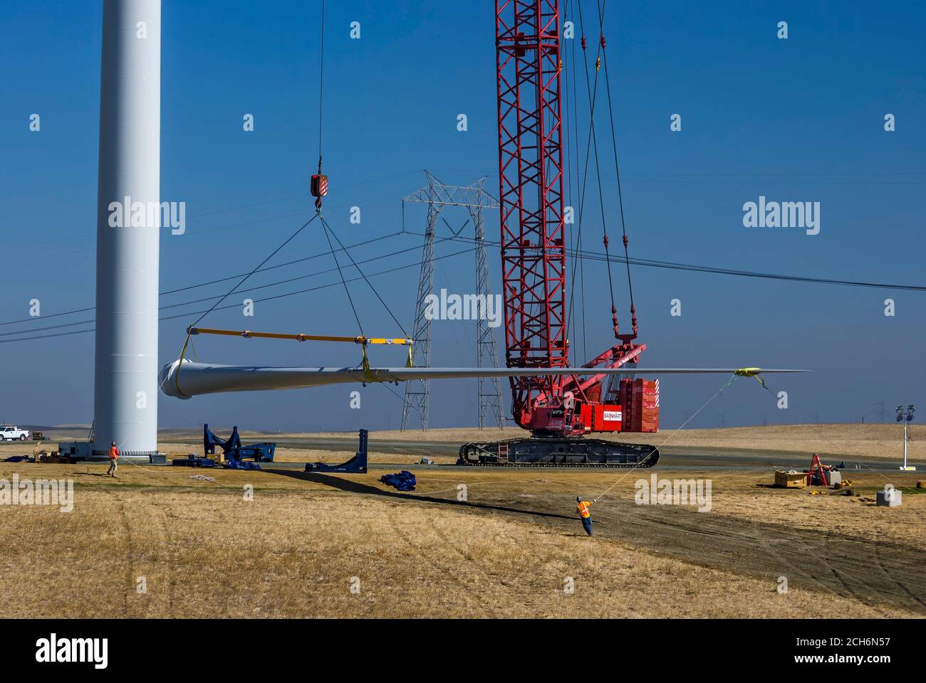 Riesiger Kran, der das Rotorblatt der Windenergieanlage hebt, um es während des Baus eines Windparks in Rio Vista, Kalifornien, in der Nähe von Sacramento, am Maschinenhaus zu befestigen Stockfoto