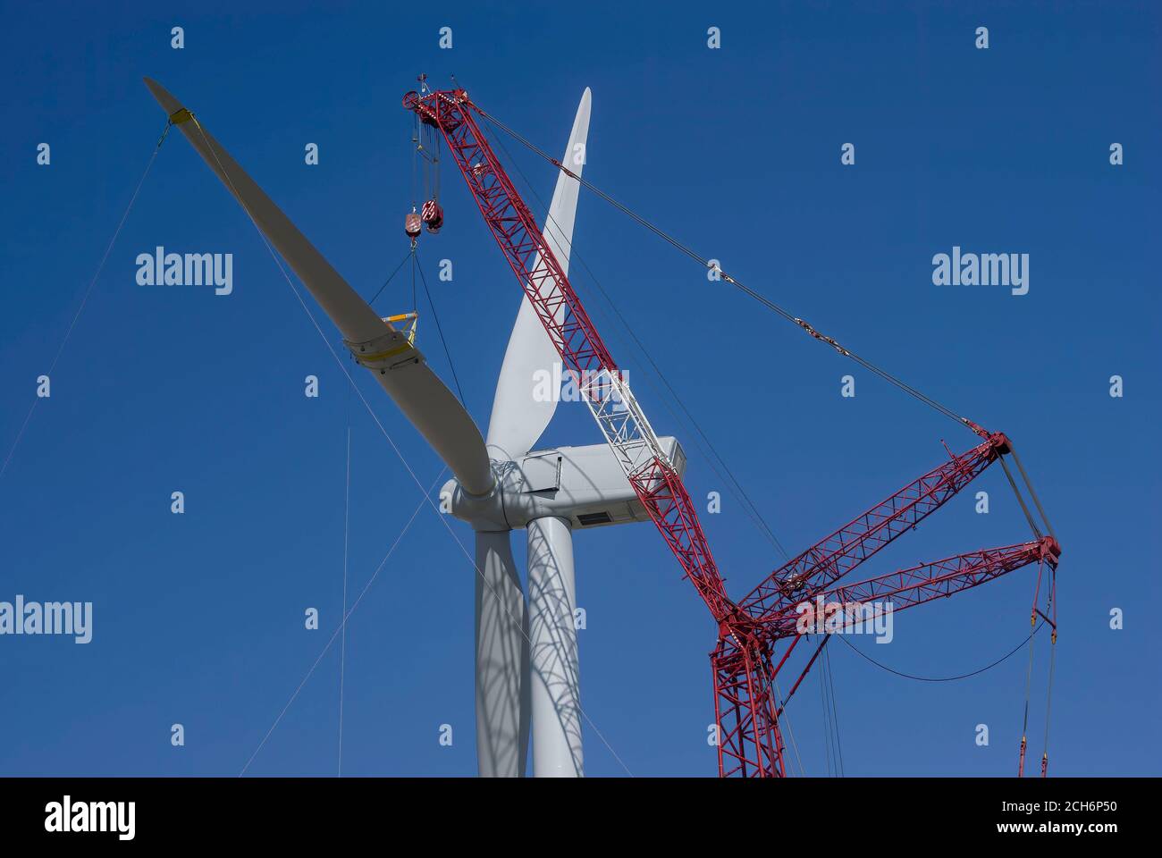 Riesiger Kran, der das Rotorblatt der Windenergieanlage hebt, um es während des Baus eines Windparks für den Stadtbezirk Sacramento in der Nähe von Rio Vis am Maschinenhaus zu befestigen Stockfoto