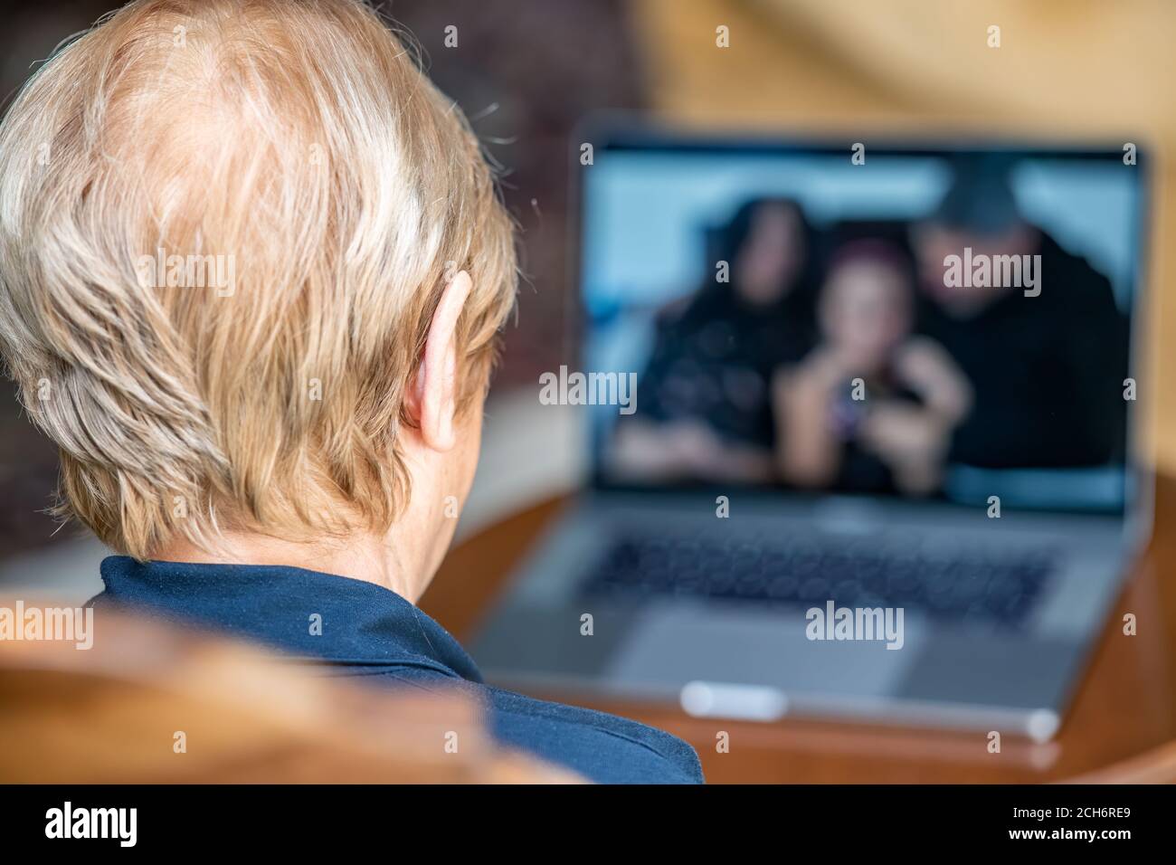 Telekonferenz der Familie in der covid Pandemie. Ältere Frau in einem Videocall mit ihren Eltern, Rückansicht Stockfoto
