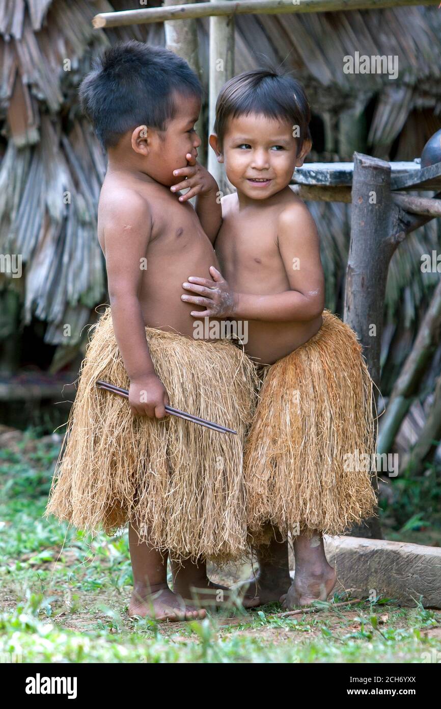 IQUITOS, PERU - 25. APRIL 2012 : Peruanische Jungen in Tradition Indische Grasröcke in einem Dorf in der Nähe von Iquitos am Amazonas in Peru. Stockfoto