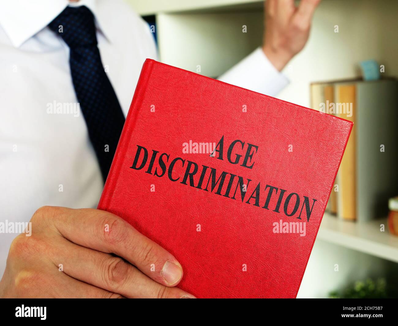 Ein Anwalt zeigt im Büro ein Buch mit Altersdiskriminierungsgesetz. Stockfoto