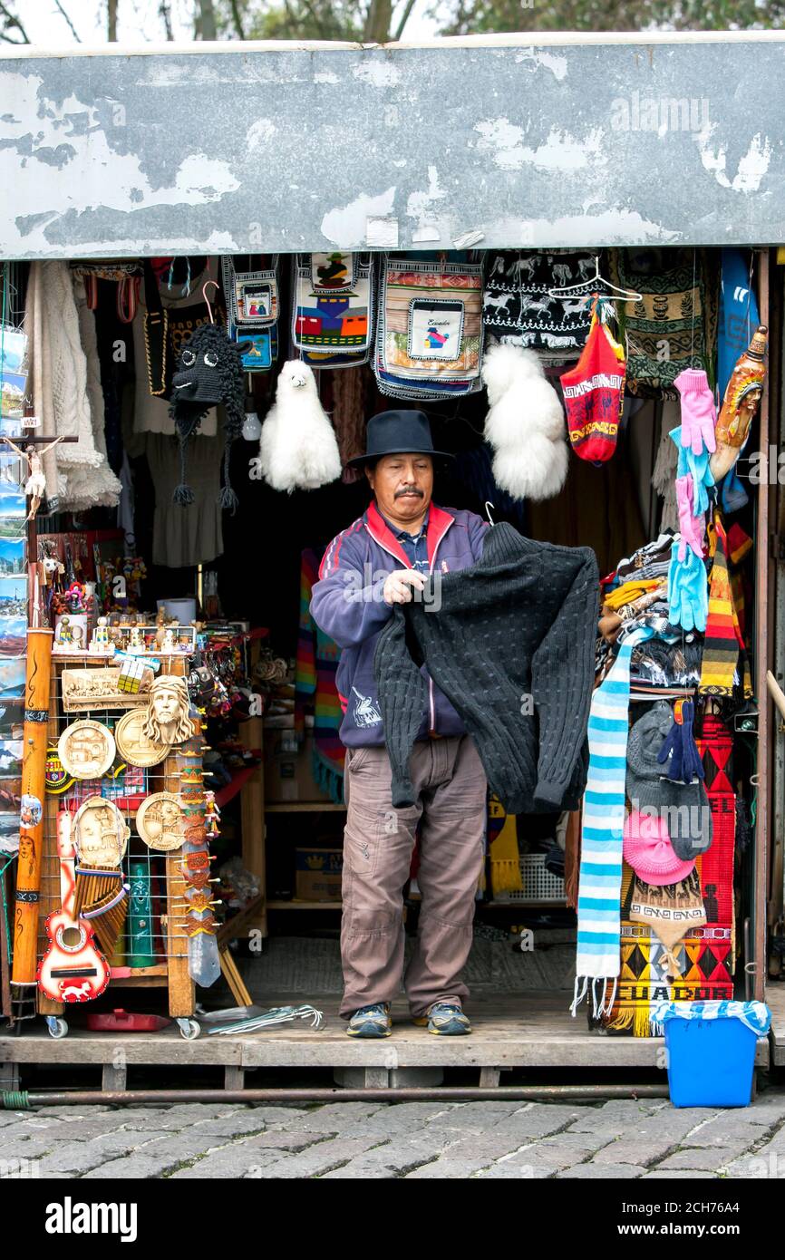 Ein Mann steht vor seinem Souvenirstand in El Panecillo, einem 200 Meter hohen vulkanischen Hügel mit Blick auf Quito in Ecuador. Er verkauft an den Tourismushandel. Stockfoto