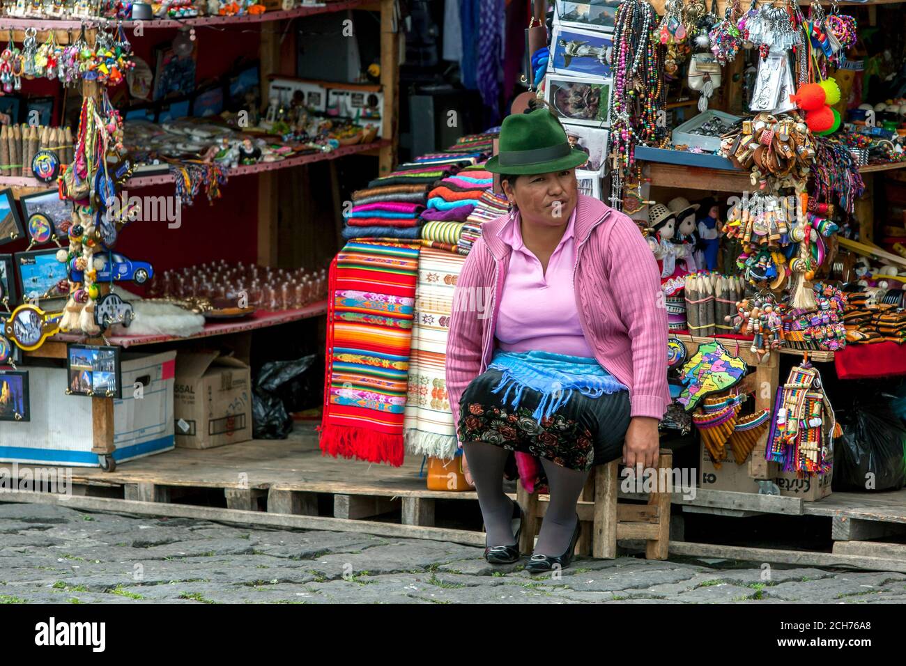 Eine Dame sitzt vor ihrem Souvenirstand in El Panecillo, einem 200 Meter hohen vulkanischen Hügel mit Blick auf Quito in Ecuador. Sie verkauft an den Tourismushandel. Stockfoto