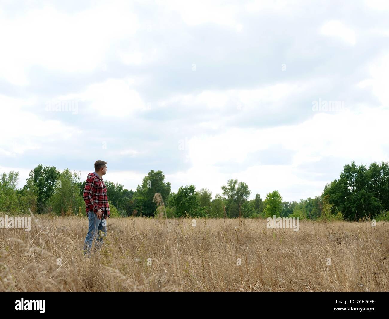 Ein Mann steht allein in einem Herbstfeld. Einsamkeit und Reisen. Stockfoto