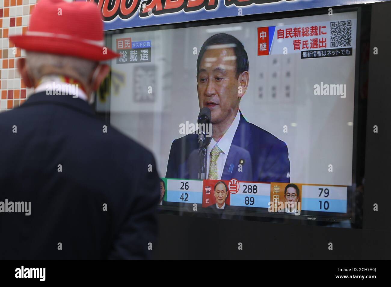 Tokio, Japan. September 2020. Tokio, Japan. September 2020. Ein Fußgänger sieht einen Bildschirm, auf dem Japans Kabinettsführer Yoshihihide Suga nach seiner Wahl zum neuen Präsidenten der regierenden Liberaldemokratischen Partei Japans (LDP) während der LDP-Führungswahl in Tokio, Japan, am 14. September 2020, spricht. Yoshihide Suga wurde am Montag auf einer gemeinsamen Plenarsitzung von Parteimitgliedern aus beiden Häusern des Parlaments und Delegierten aus lokalen Kapiteln zum neuen Präsidenten der regierenden LDP gewählt. Kredit: Du Xiaoyi/Xinhua/Alamy Live Nachrichten Gutschrift: Xinhua/Alamy Live Nachrichten Stockfoto