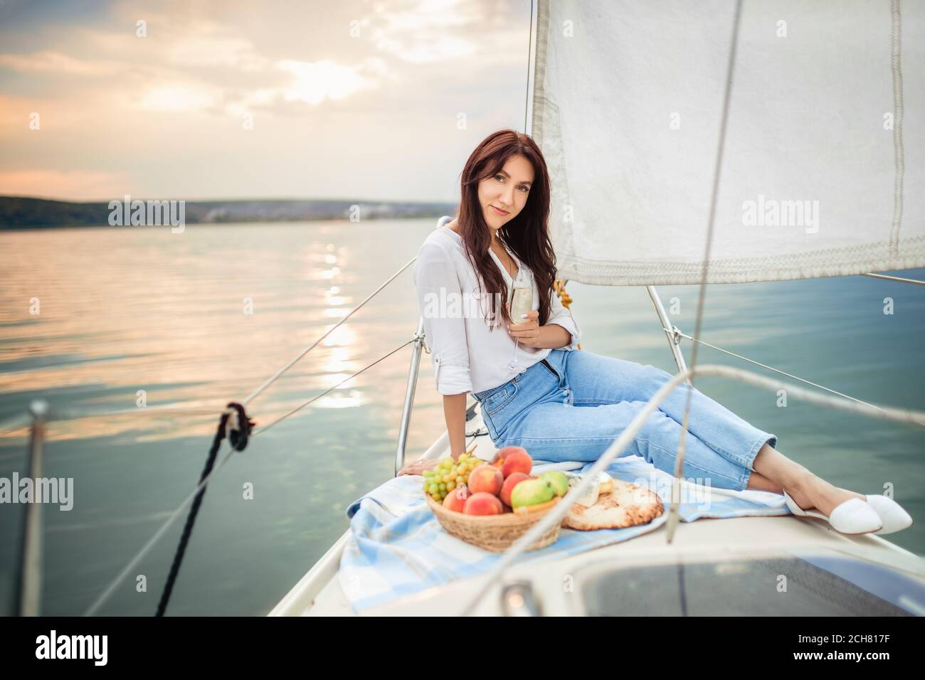 Frau mit einem Glas Champagner auf der Yacht Stockfoto