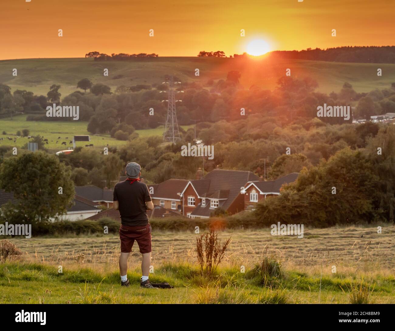 Ein junger Mann genießt den Sonnenuntergang über der englischen Landschaft In Staffordshire Stockfoto