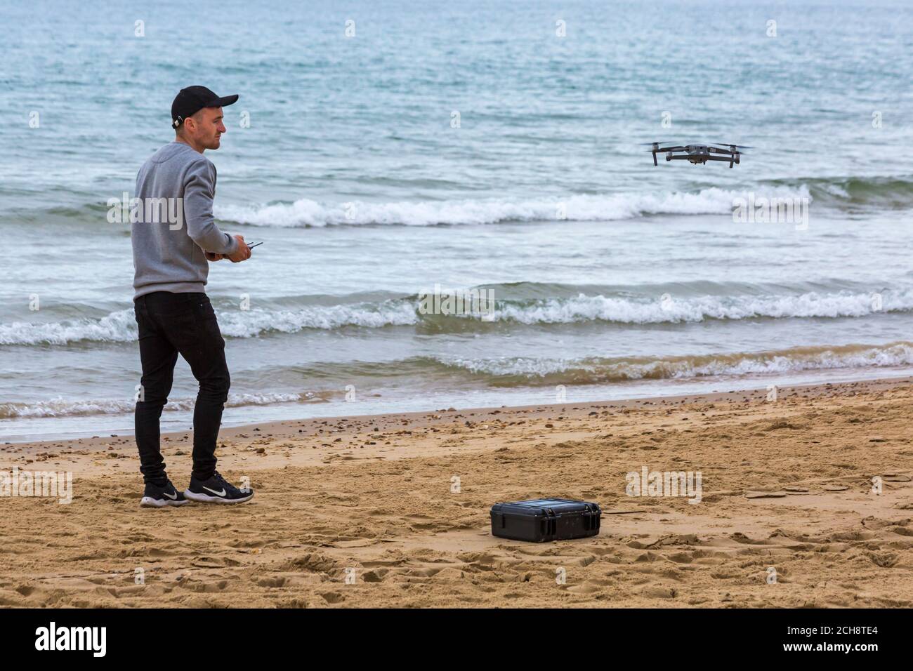 Junger Mann, der eine Drohne bei einer Veranstaltung am Bournemouth Beach, Bournemouth, Dorset UK im September betreibt Stockfoto