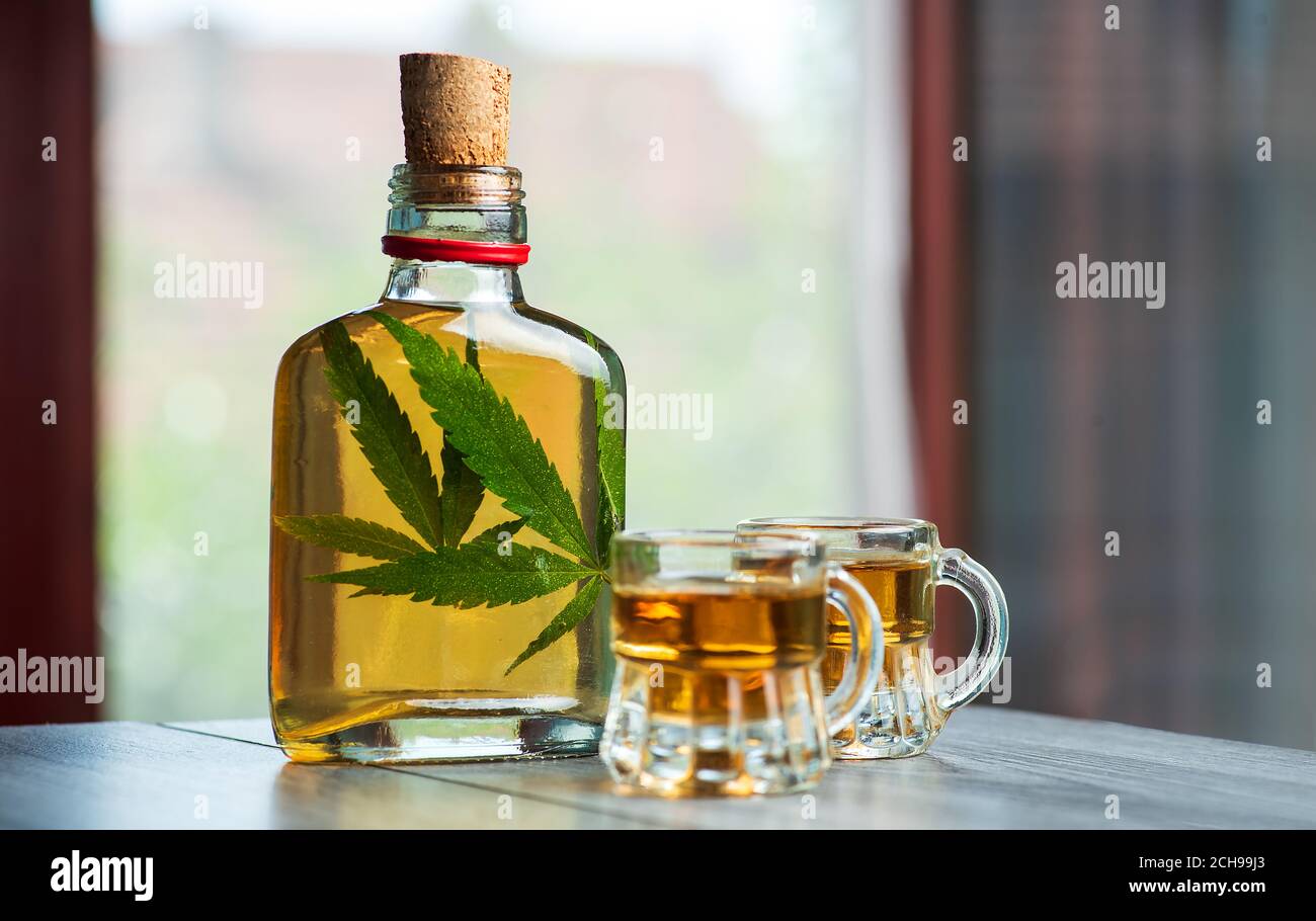 Alkoholisches Getränk Whiskey Brandy oder Schnaps mit Marihuana infundiert Cannabisblatt in der Flasche Stockfoto