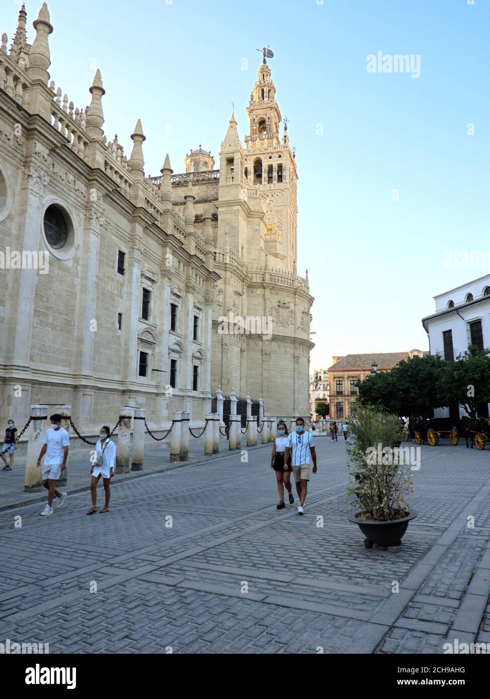 Sevilla, Spanien; 2. August 2020: Maskiertes Paar, das während der Coronavirus-Pandemie in der Nähe der Kathedrale von Sevilla spazieren ging Stockfoto