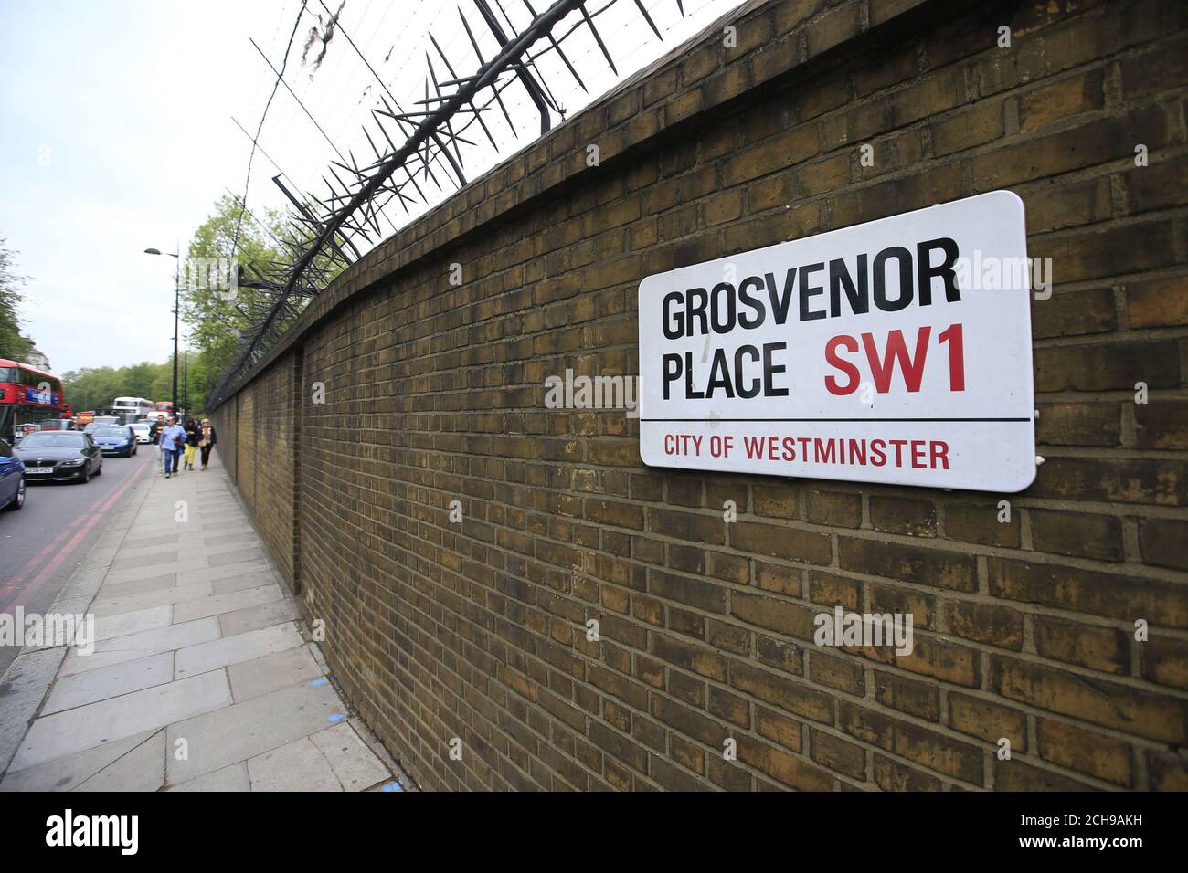 Fußgänger passieren eine Mauer um den Buckingham Palace im Zentrum von London. Scotland Yard hat gesagt, dass ein 41-jähriger Mann verhaftet wurde, nachdem er am Mittwochabend eine Umfassungsmauer am Palast bestochen hatte. Stockfoto