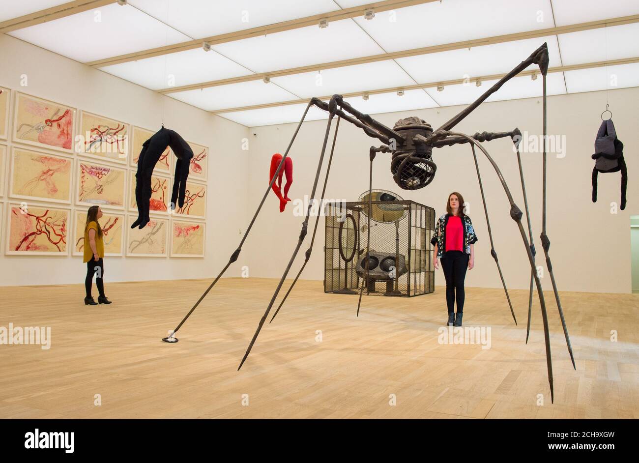 Die Besucher sehen Kunstwerke wie "Spider" von Louise Bourgeois, eines der Kunstwerke, die im neuen Switch House Extension der Tate Modern in Southwark, London, ausgestellt werden. Stockfoto