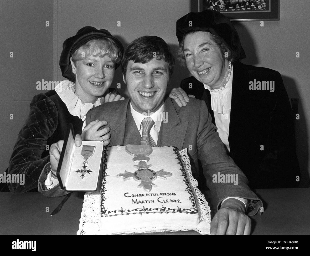 Martin Cleaver, 26, Mitarbeiter-Fotograf der Pressevereinigung, wird von seiner Freundin Yvonne Baldwin (l.) und Mutter Nancy Cleaver (r.) flankiert, um einen MBE zu feiern, den er für seine Berichterstattung über den Südatlantikkrieg gesammelt hat. Stockfoto