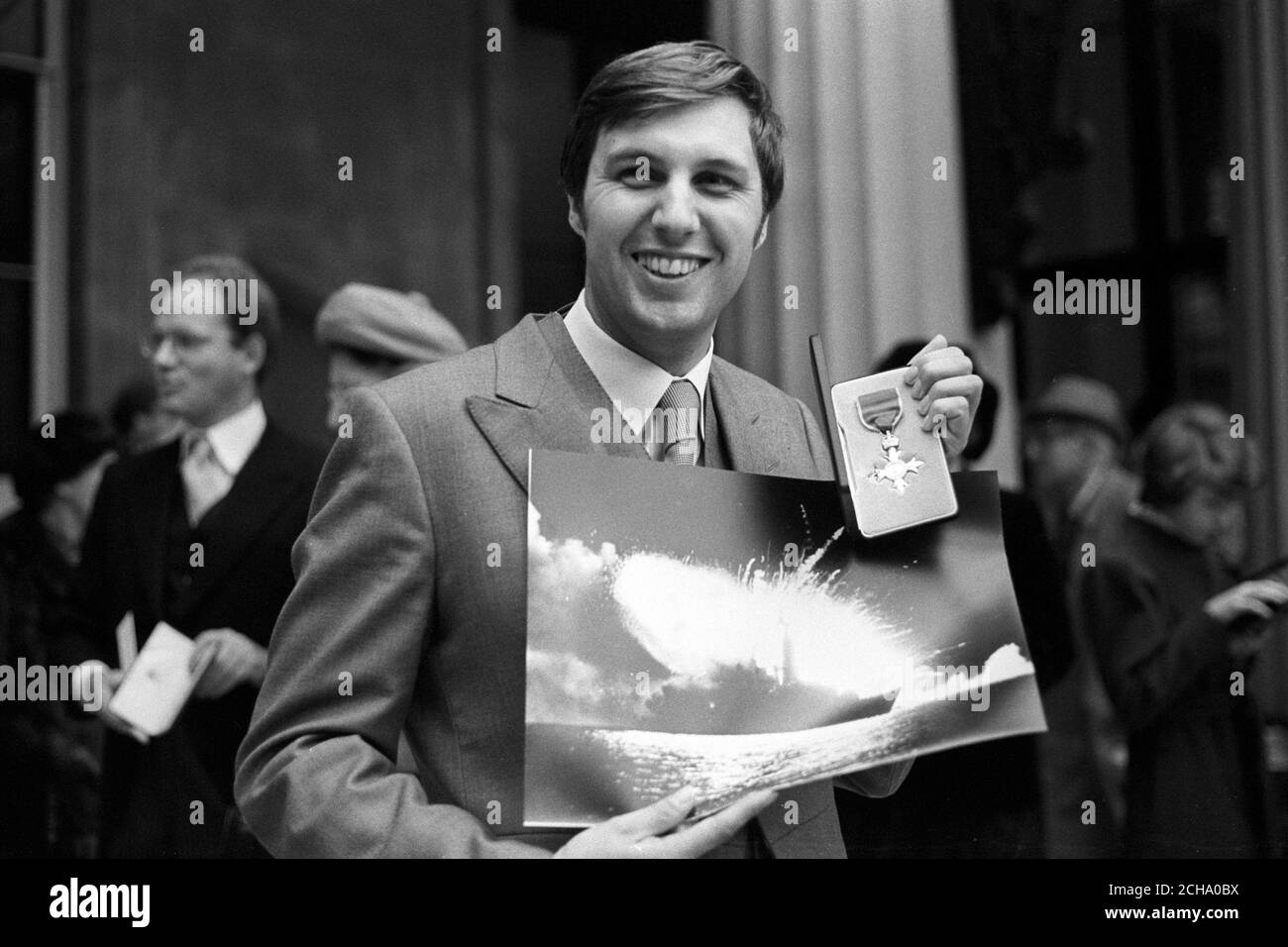 Martin Cleaver, 26, Mitarbeiter-Fotograf der Press Association im Falklands-Krieg, mit seinem MBE und preisgekröntem Bild von HMS Antelope (siehe URN 1252500) vor dem Buckingham Palace. Stockfoto
