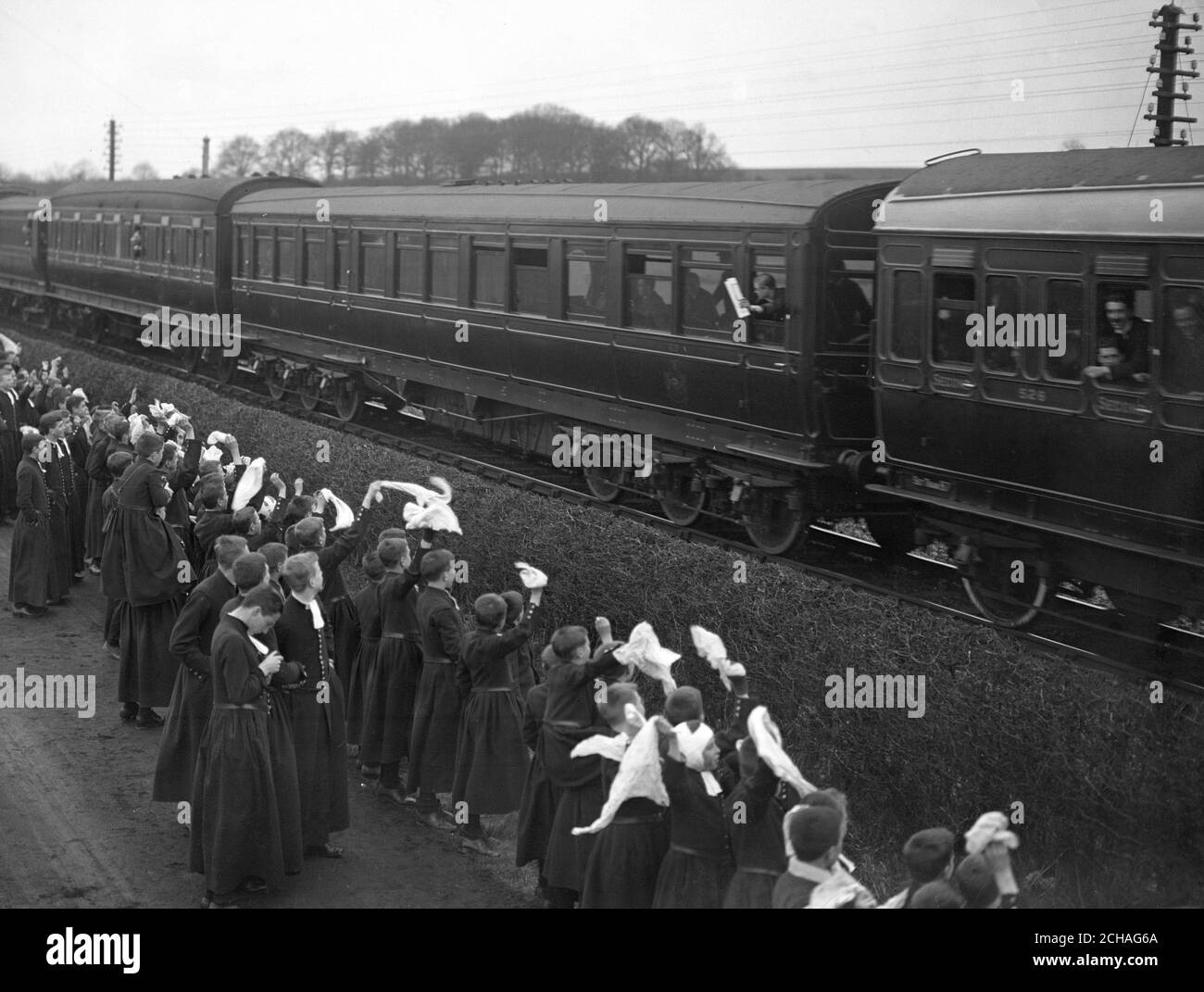 Bluecoat Boys jubeln dem Prince of Wales zu, der sich aus einem Kutschenfenster lehnt. Stockfoto