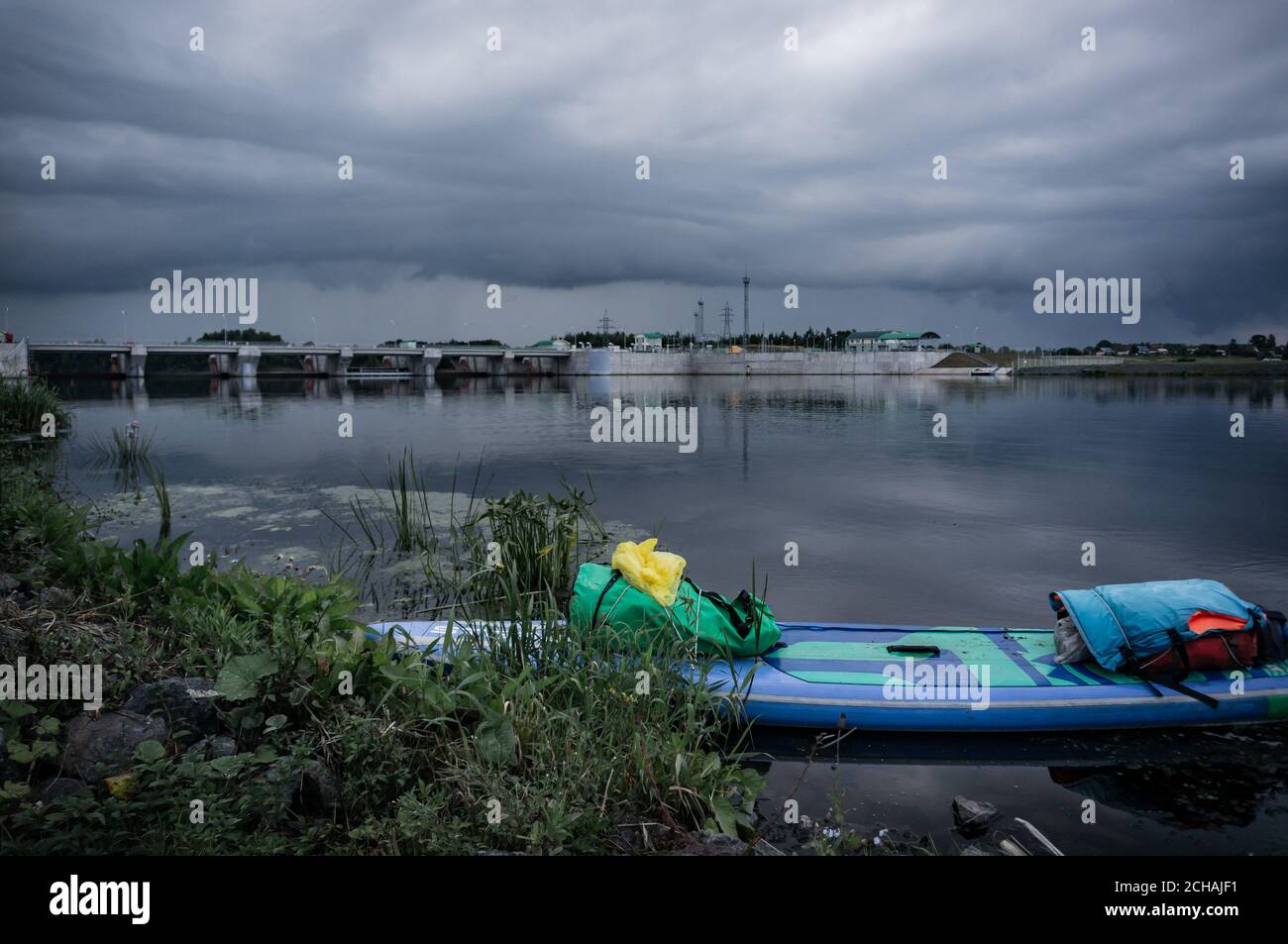 Paddleboard Rafting, aufblasbares Brett auf dem Hintergrund des Wasserkraftwerks, Stockfoto