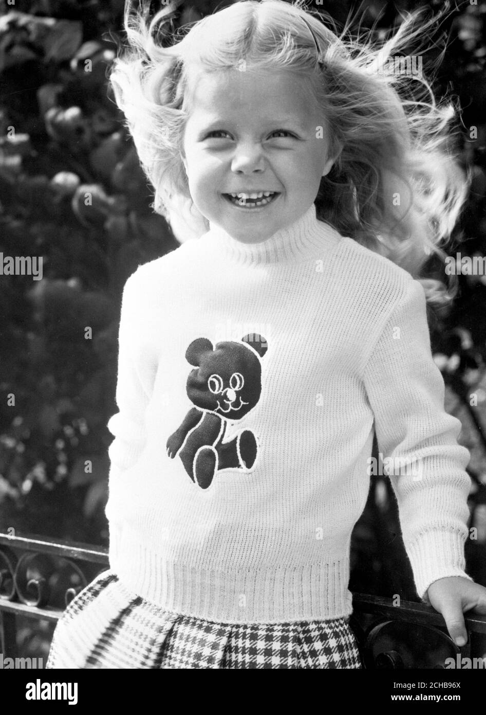 Ein junges Model trägt einen Pullover mit Teddybär-Motiv, der beim Drücken quietscht, erhältlich in British Home Stores. Stockfoto
