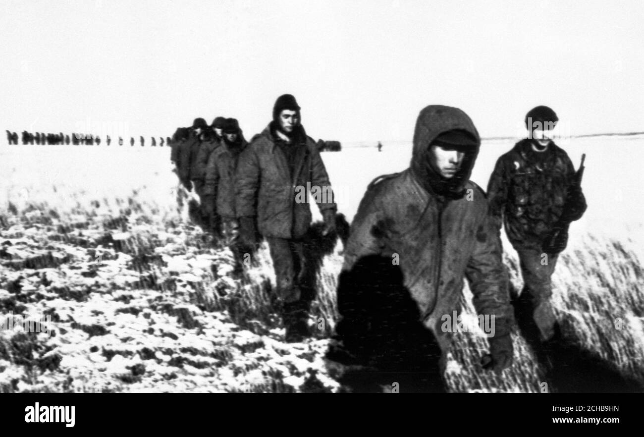 Einige der 1,400 argentinischen Gefangenen, die in Goose Green gefangen genommen wurden, werden in Gefangenschaft über die schneebedeckte Landebahn in East Falkland geführt. *Poolbild von Tom Smith, vom Daily Express. Stockfoto