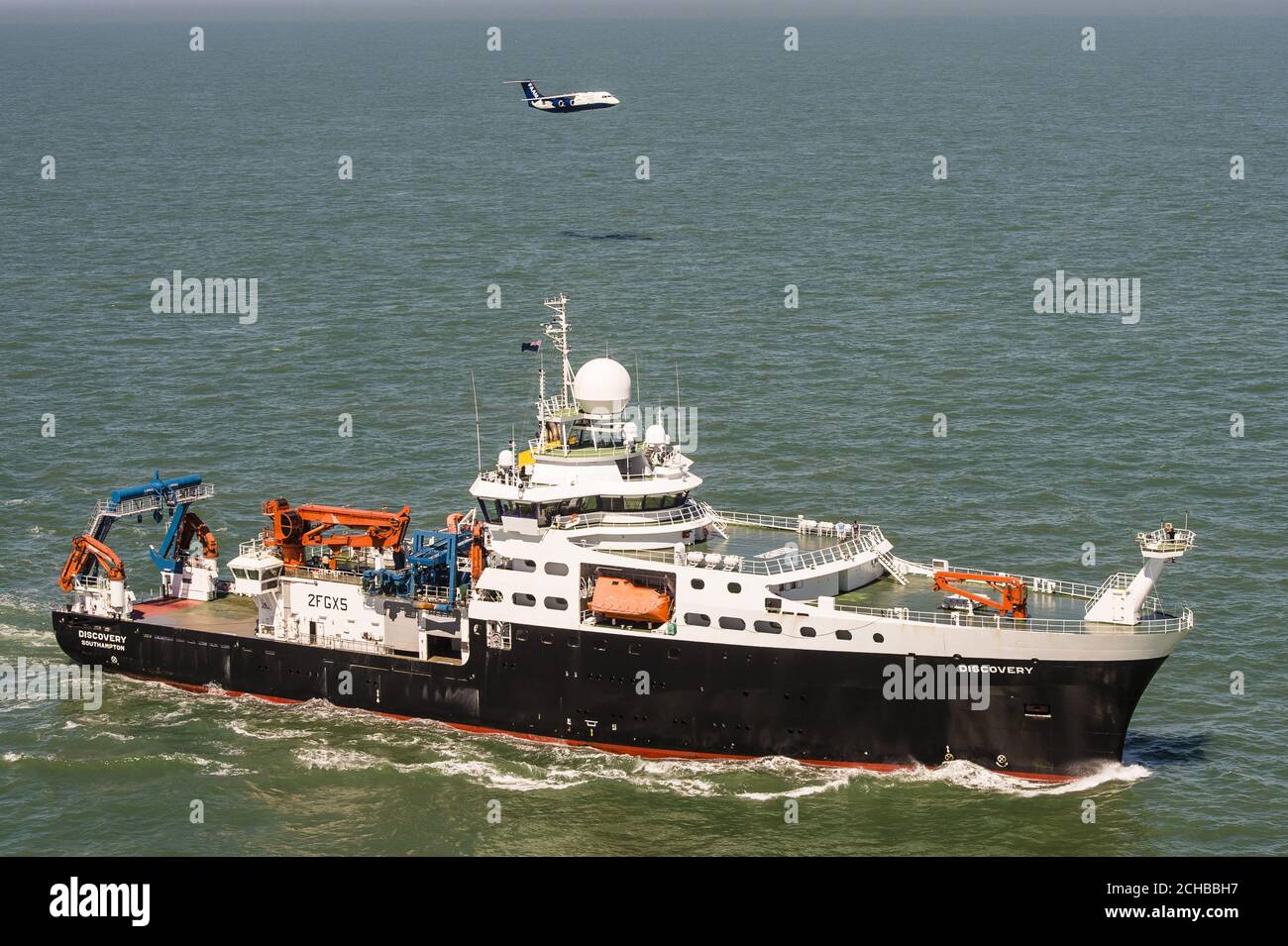 Das britische Natural Environment Research Council (NERC)-Flugzeug, genannt Facility for Airborne Atmospheric Measurements (FAAM) und Schiff RSS Discovery zusammen in der Solent vor der Isle of Wight und Portsmouth. Stockfoto