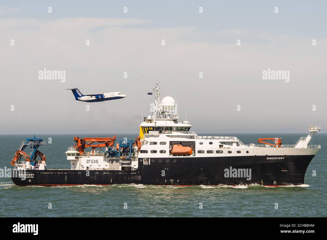 Das britische Natural Environment Research Council (NERC)-Flugzeug, genannt Facility for Airborne Atmospheric Measurements (FAAM) und Schiff RSS Discovery zusammen in der Solent vor der Isle of Wight und Portsmouth. Stockfoto