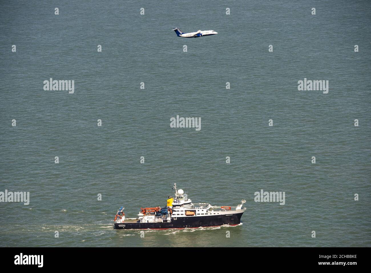 Das britische Natural Environment Research Council (NERC)-Flugzeug, genannt Facility for Airborne Atmospheric Measurements (FAAM) und Schiff RSS Discovery zusammen in der Solent vor der Isle of Wight und Portsmouth. Stockfoto