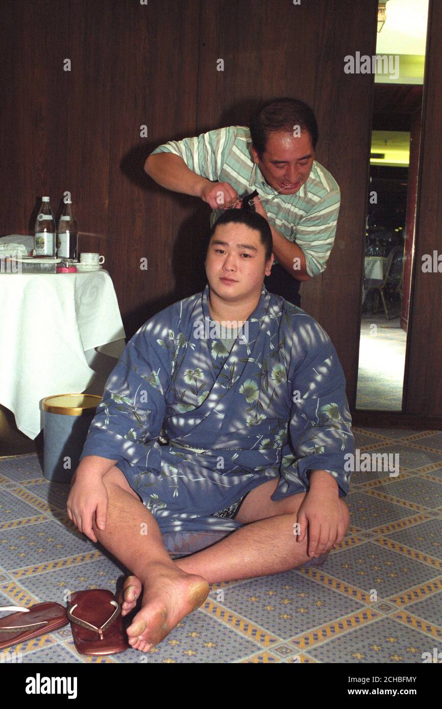 Ein Tokoyama (Friseur) im Royal Garden Hotel, Kensington, besucht einen der Sumo-Ringer in London für das Grand Sumo Turnier in der Royal Albert Hall. Stockfoto