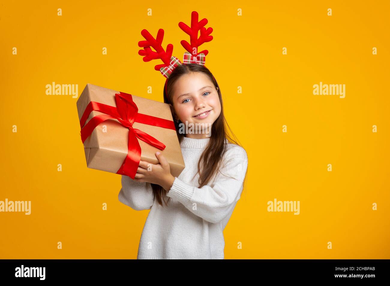 Geschenk vom Weihnachtsmann. Fröhliche Mädchen hält präsent und hört Box Stockfoto