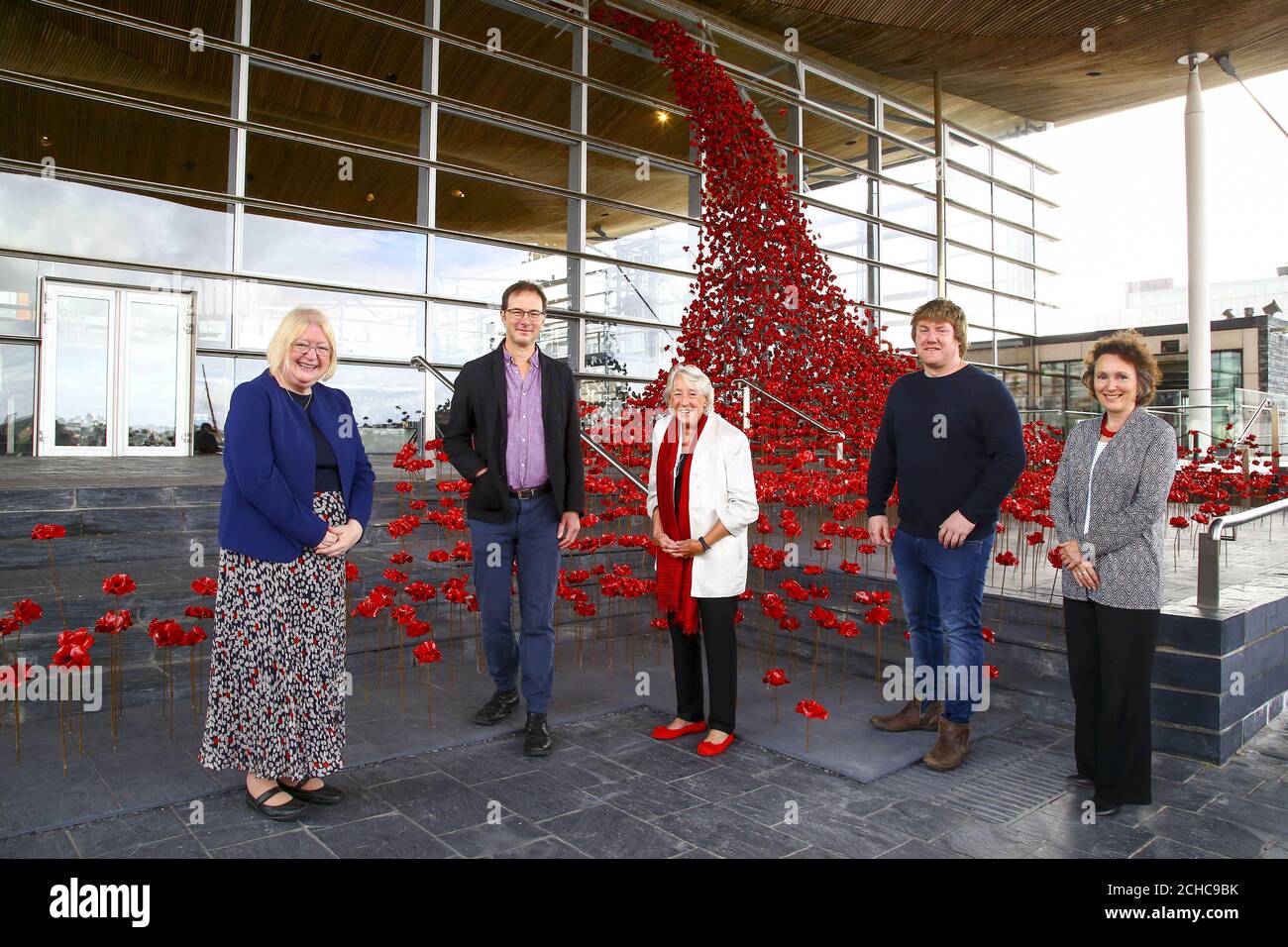 NUR REDAKTIONELLE VERWENDUNG (von links nach rechts) Ann Jones AM, Deputy Presiding Officer National Assembly for Wales, Designer Tom Piper, Lady Susie Sainsbury, Künstler Paul Cummins und Jenny Waldman, Direktorin von 14-18 NOW, enthüllen Weeping Window bei Y Senedd, der Nationalversammlung für Wales in Cardiff, Das ist aus der Mohninstallation Blood Swept Lands und Seas of Red. Stockfoto