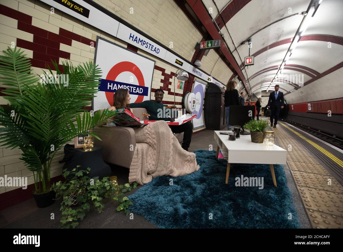 Amber O'Shea und Benjamin Opuku nehmen an einem einzigartigen kulinarischen Erlebnis Teil, um Papa Johns neue Pizza „Papa's Deep Crust“ auf dem Bahnsteig der Hampstead Station, der tiefsten U-Bahnstation der Londoner U-Bahn, zu lancieren. Stockfoto