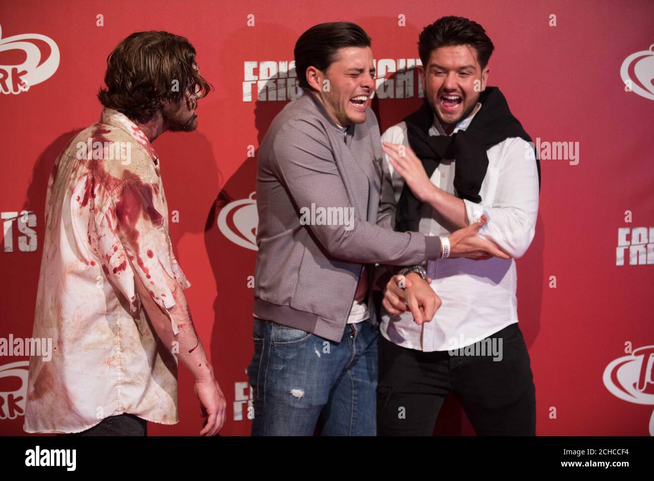 REDAKTIONELLE VERWENDUNG NUR TOWIE Jordan Brook (Mitte) und Jack Rigden (rechts) reagieren auf &Ocirc;Zombies&Otilde; beim Start der jährlichen Fright Nights-Saison des THORPE PARK Resort&Otilde, die zwei neue Live-Action-Labyrinthe enthält, die von der Fernsehsendung The Walking Dead inspiriert wurden. Stockfoto