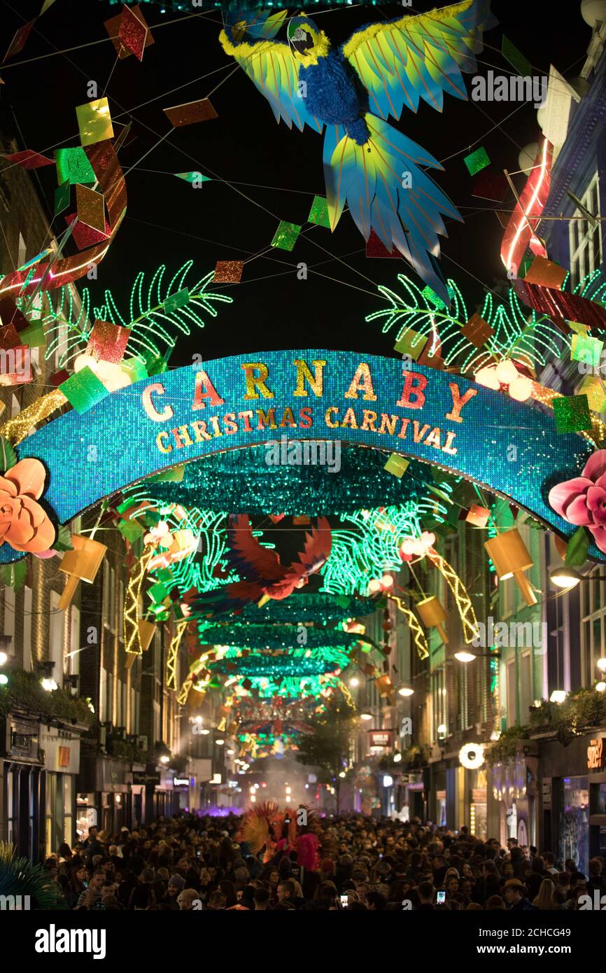 REDAKTIONELLE VERWENDUNG NUR Menschenmassen versammeln sich zum Carnaby Weihnachtsbeleuchtung einschalten in Carnaby, London, die ein Karnevalsthema hat. Stockfoto