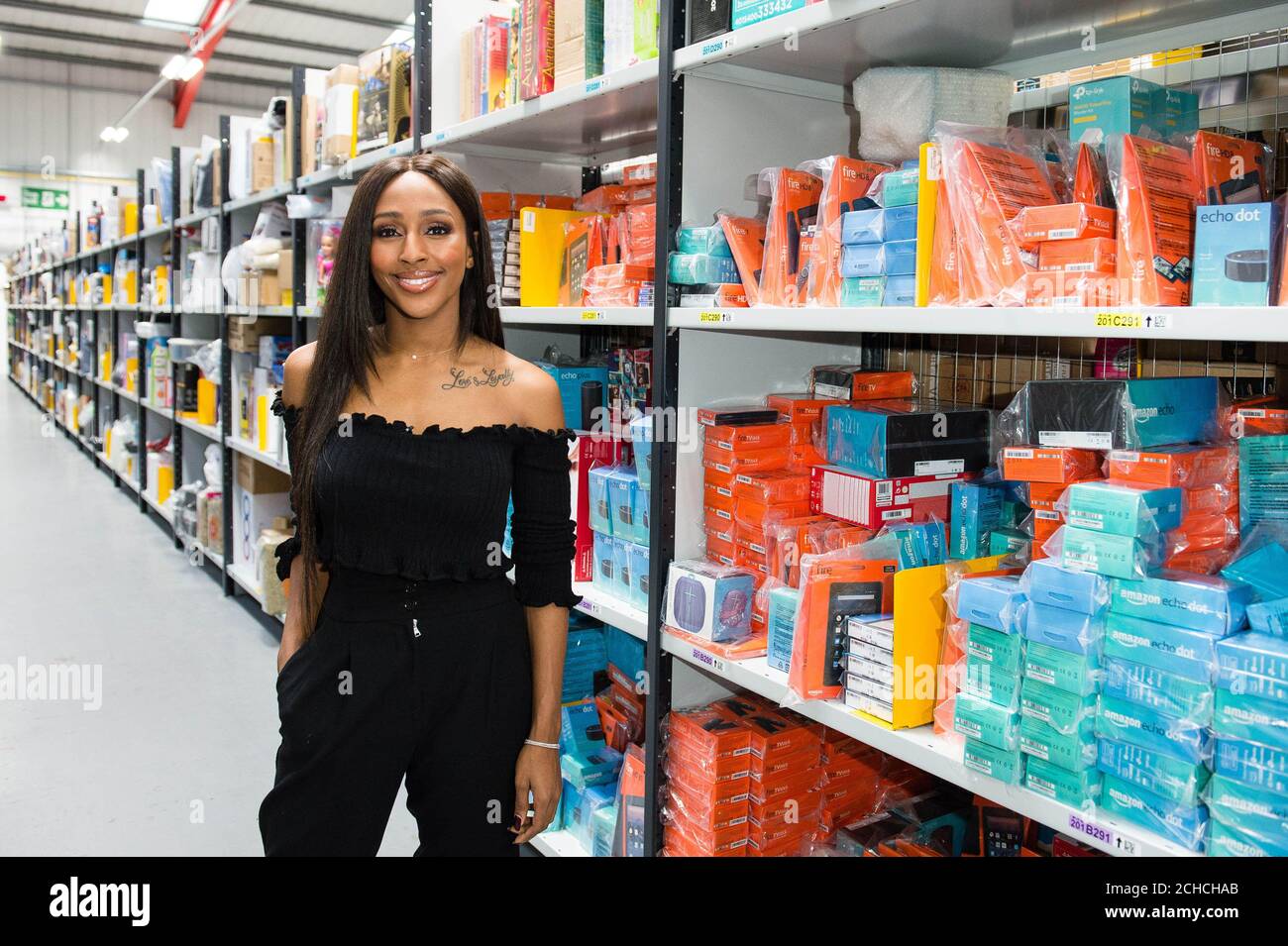 Alexandra Burke wählt Amazon-Artikel im Vertriebszentrum des Einzelhandels in Hatfield aus, bevor Prime Now überraschend an die Elizabeth Anderson Garret School (ihre alte Sekundarschule) in Islington, London, geliefert wird, um den Black Friday zu starten. Stockfoto