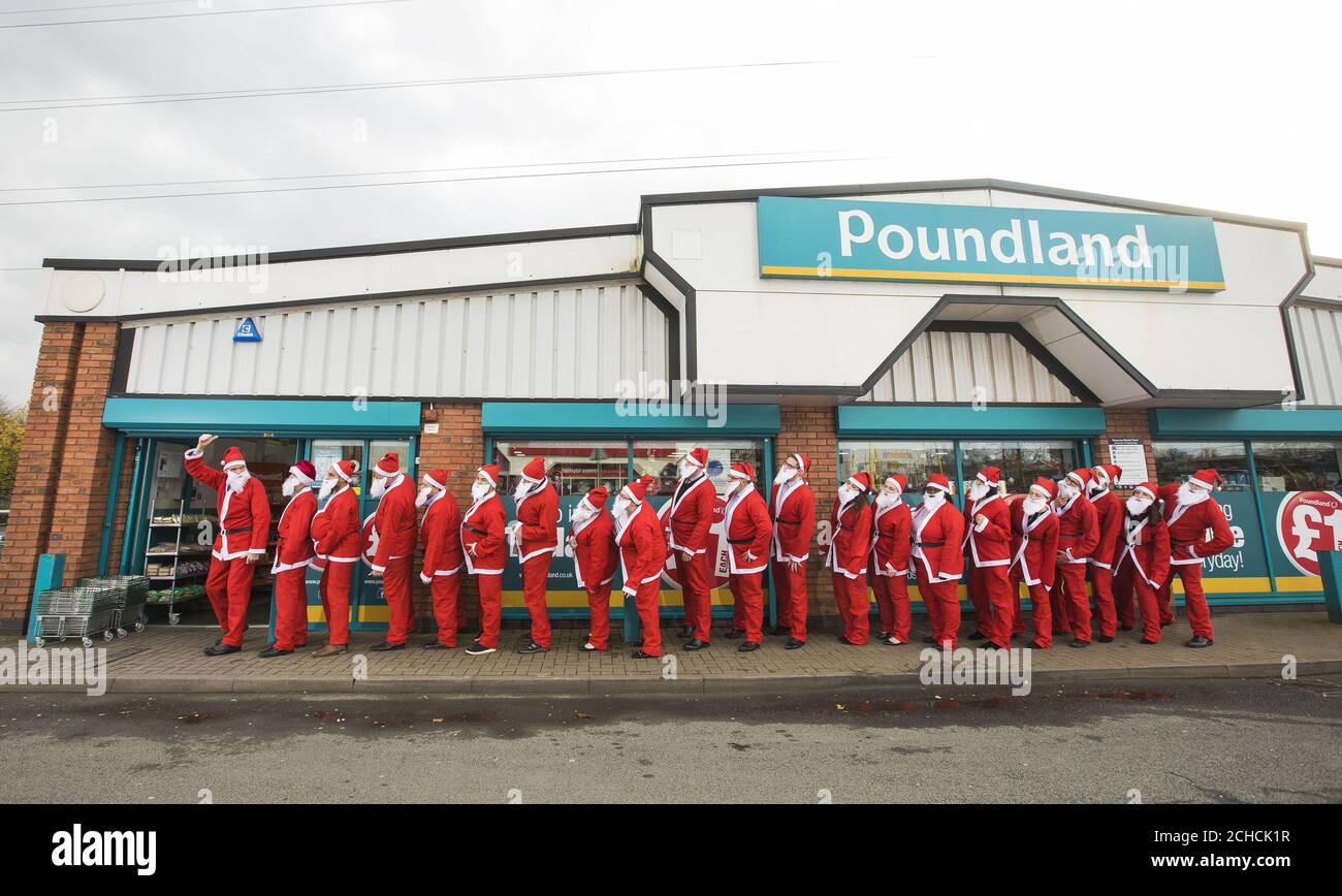 In Poundland kommen Menschen zusammen, die als Weihnachtsmann verkleidet sind, um die jährliche Mission des Erwerbs eines „Secret Santa“-Geschenks zu übernehmen, da neue Untersuchungen ergeben, dass Mitglieder der britischen Öffentlichkeit in diesem Jahr mehr als £320 Millionen für das wachsende Ritual West Midlands ausgeben werden. Stockfoto