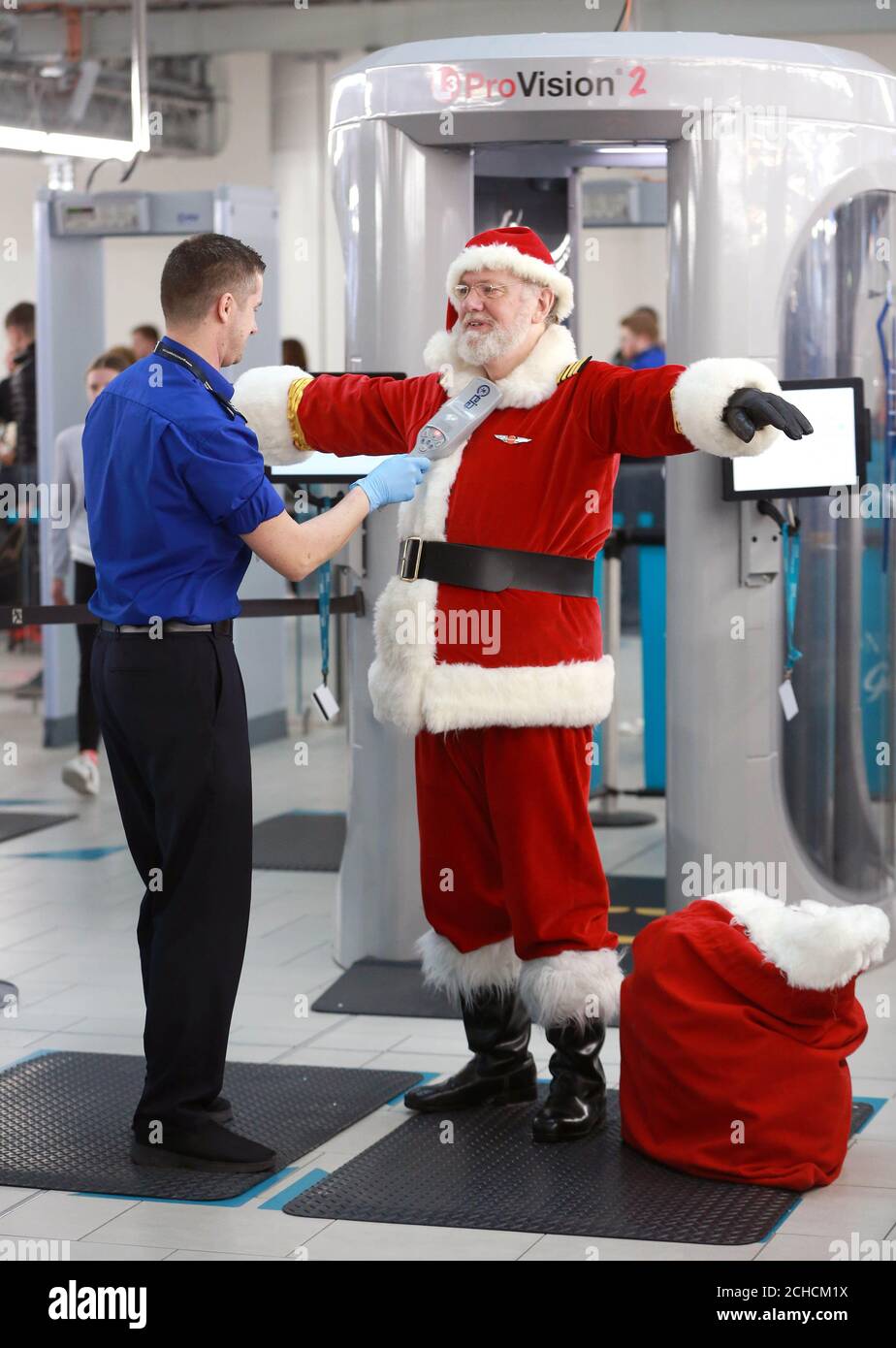 REDAKTIONELLE VERWENDUNG NUR EIN Mann, der als Weihnachtsmann am Flughafen Gatwick durch die Sicherheitskontrolle geht, während easyJet von Dezember 19 bis Heiligabend auf über 100 europäischen Flügen Fluggrotten einführt. DRÜCKEN SIE ZUORDNUNG. Foto. Ausgabedatum: Dienstag, 19. Dezember 2017. Sicherheitskräfte inspizierten den Geschenken des Weihnachtsmanns, als er sich vorbereitete, an Bord eines easyJet Airbus A320 zu gehen, um Passagiere zu überraschen. 20,000 Passagiere erleben die neuen festlichen Grotten an Bord und treffen den Weihnachtsmann auf Strecken von Großbritannien nach Frankreich, Deutschland, Italien, Portugal, Spanien und den Niederlanden. Bildnachweis sollte lauten: Matt Alexander/P Stockfoto