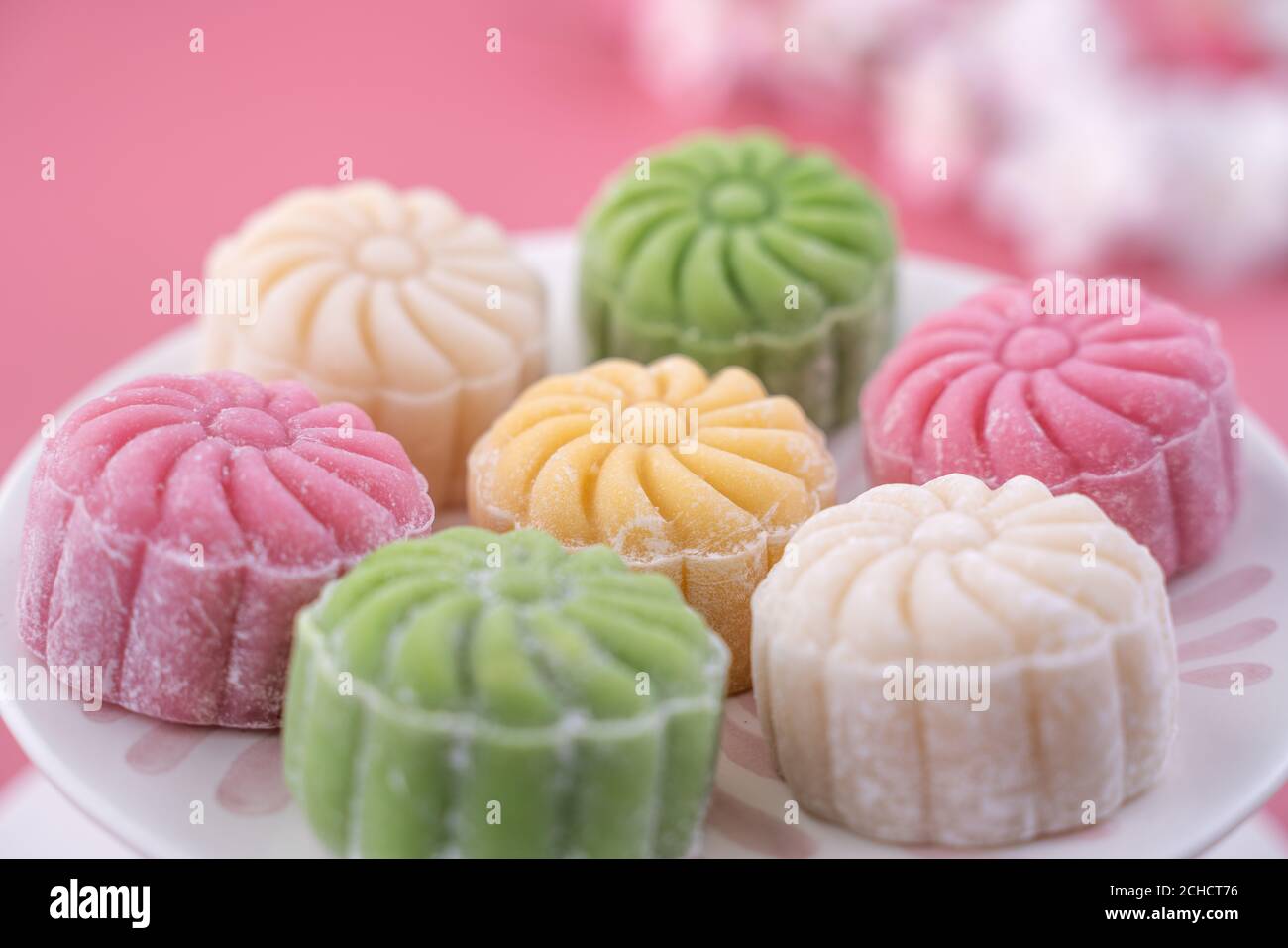 Bunte Schneehaut Mondkuchen, süße verschneite Mondkuchen, traditionelle herzhafte Dessert für Mid-Autumn Festival auf pastellrosa Hintergrund, Nahaufnahme, Leben Stockfoto