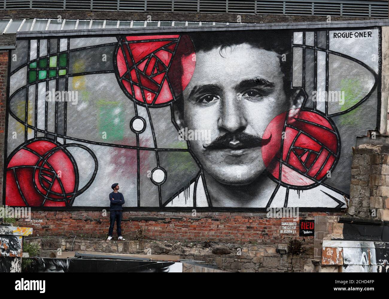 Künstler Bobby McNamara als Rogue bekannt - ein Blick auf sein neuestes Werk, eine riesige street art Wandbild zu Charles Rennie Mackintosh gewidmet auf eine große Wand mit Blick auf den Clutha bar in Glasgow gemalt. Stockfoto