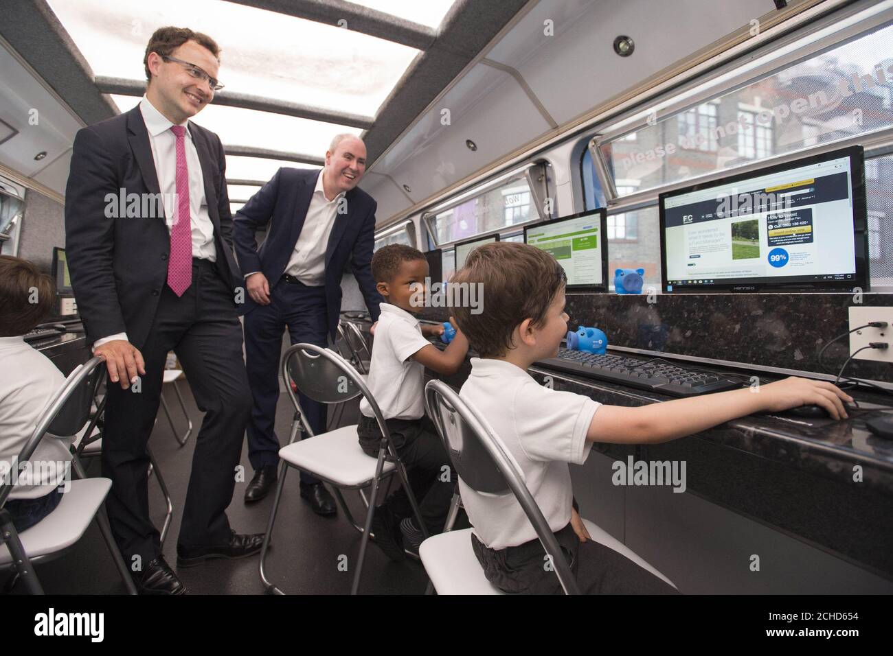 Edward knapp, Vorstandsmitglied von F&C Investment Trust (links) und Paul Niven, Fondmanager bei F&C Investment Trust, mit Schülern der Wyvil Primary School während einer UK Road Tour mit der Shakespeare Schools Foundation, Die in diesem Sommer 1,000 Grundschulkinder treffen und Schulungen zu verschiedenen Geldthemen anbieten wird, darunter Sparen, der Wert des Geldes und wie das Geld im Laufe der Zeit wächst. Roadshow in Zusammenarbeit mit BMO Global Asset Management. Stockfoto