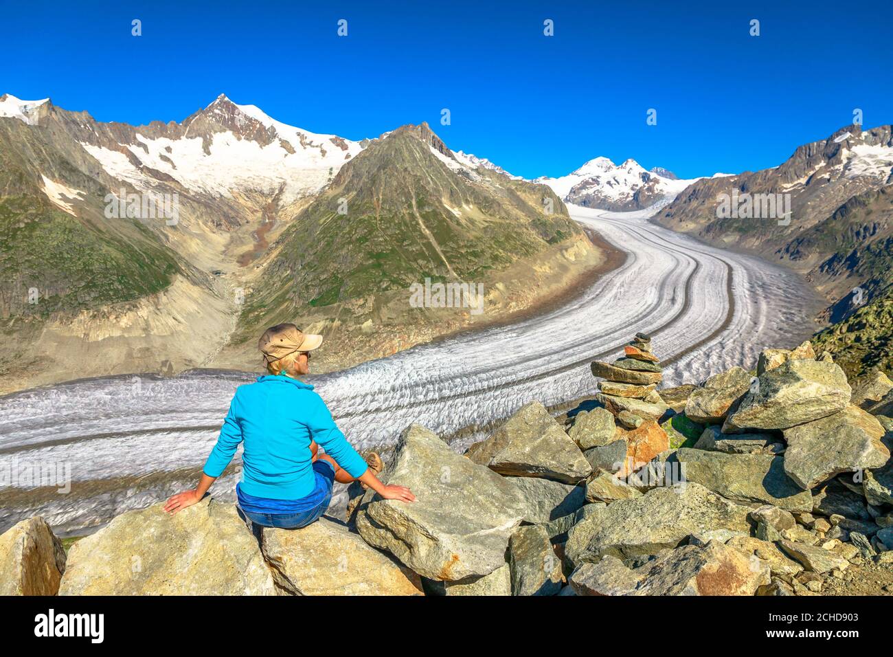 Wanderfrau nach dem Trekking in den Schweizer Alpen, Kanton Wallis, Schweiz, Europa. Frau Blick Aletsch Gletscher vom Eggishorn Gipfel mit gedeckelt Stockfoto