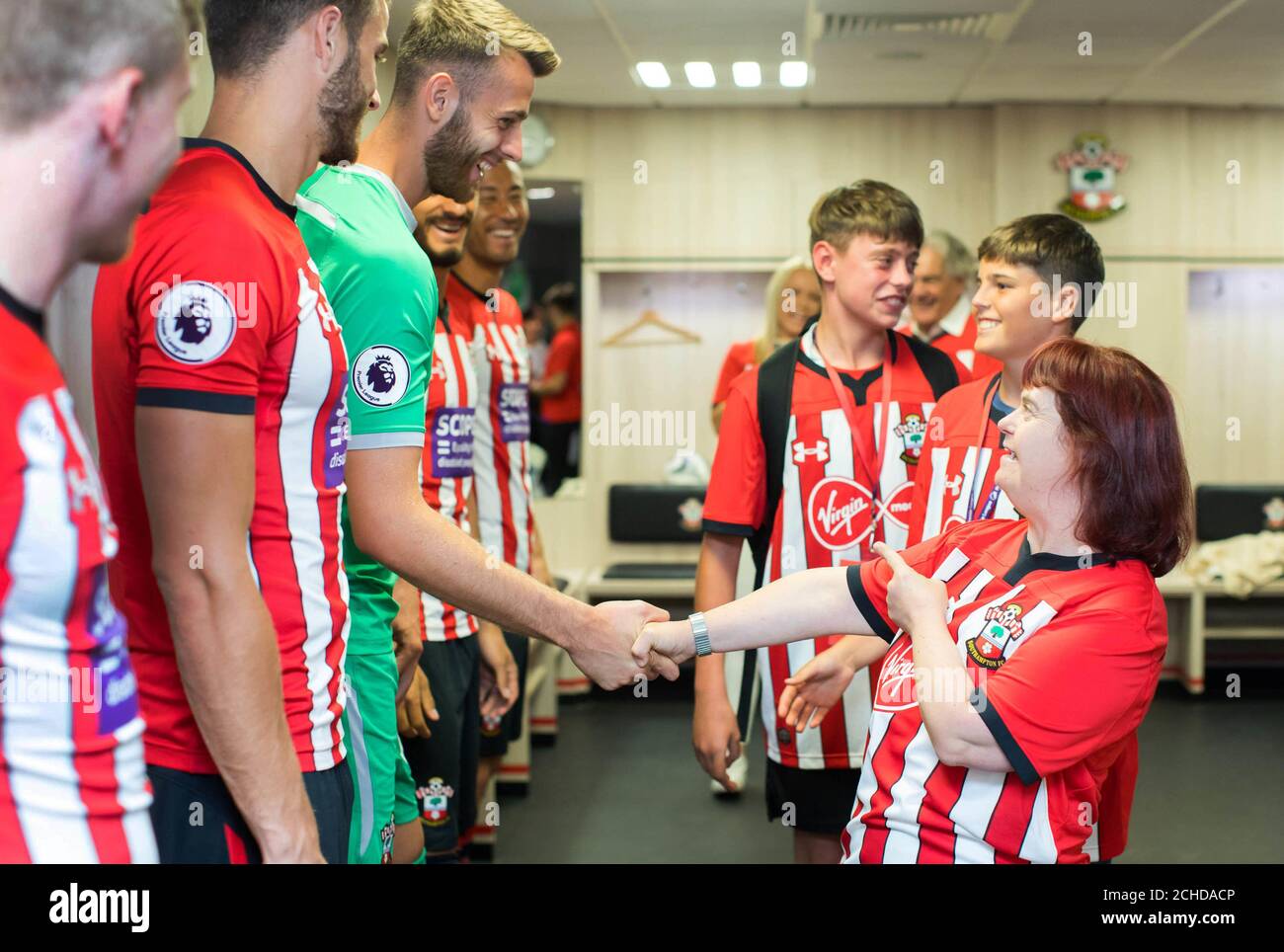 Southampton-Torhüter Angus Gunn trifft die Saints-Fan Helen Burns, während Virgin Media, die offiziellen Trikot-Sponsoren des Teams, das Sponsoring des Clubs an The Scope spendet, um die Behindertengleichstellung an der Front und im Zentrum des Fußballs im St. Mary's Stadium in Southampton zu platzieren. Stockfoto