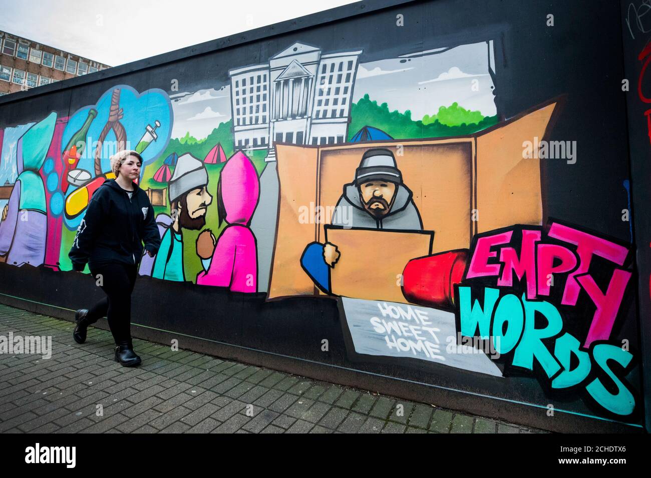 Eine Frau geht an dem Wandgemälde „Still Somebody: Voices for Change“ in Belfast vorbei, das gegen das angebliche Fehlen von Maßnahmen von Stormonts Politikern wegen Obdachlosigkeit protestiert. Die neuen Zahlen der nordirischen Wohnungsbaudirektorinnen und -Exekutive haben die Notlage der alleinstehenden Männer besonders hervorgehoben, für die nicht genügend ein-Zimmer-Wohnungen verfügbar sind. Stockfoto