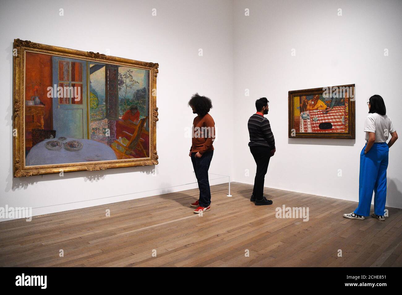 Galerieassistenten schauen sich Dining Room in the Country (links) und Coffee (rechts) während einer Presseinterpremiere für Pierre Bonnard: The Color of Memory in der Tate Modern in London an. Stockfoto