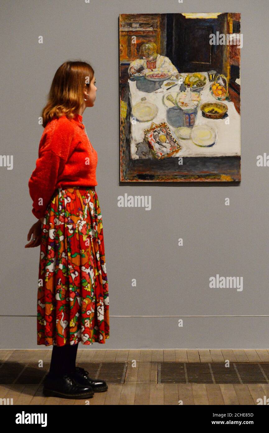 Ein Galerist schaut auf den Tisch, während einer Presseinterpremiere für Pierre Bonnard: The Color of Memory, in der Tate Modern in London. Stockfoto