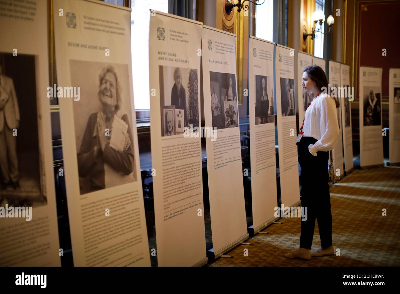 Ein Teilnehmer betrachtet Tafeln, die die Lebensgeschichte der Holocaust-Opfer bei der jährlichen Gedenkveranstaltung zum Holocaust Memorial Day im Foreign & Commonwealth Office in London zeigen. Stockfoto