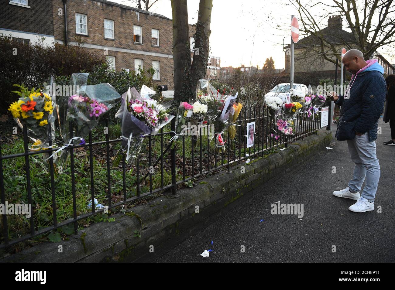 Ein Mann, der florale Tribute bei der Szene in der Forest Road im Osten Londons ansieht, wo eine 21-jährige Frau starb, nachdem sie von einem Polizeiauto auf einen Anruf von 999 geschlagen wurde. Stockfoto
