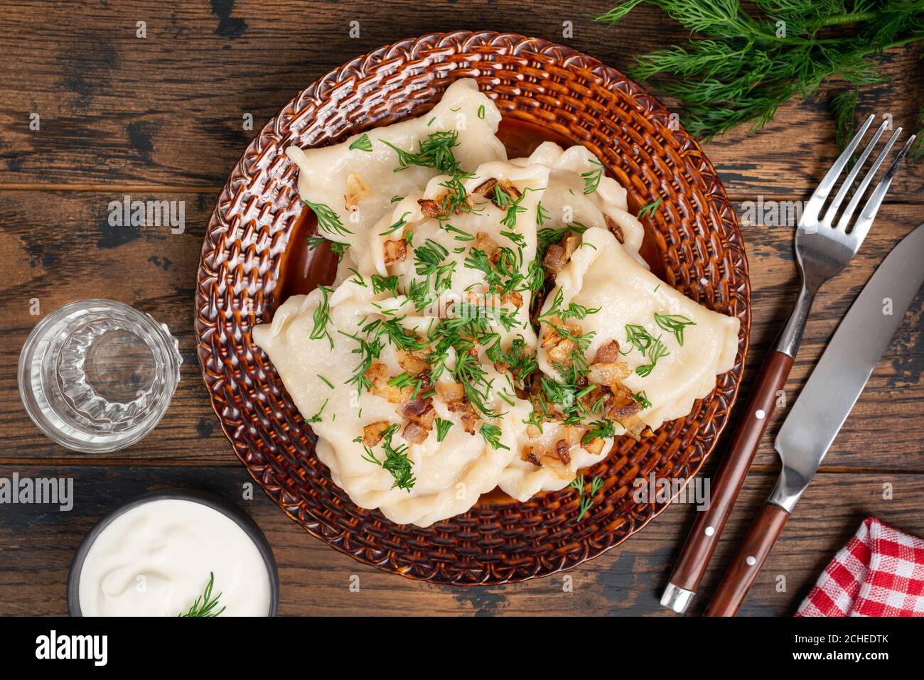 Pierogi mit gebratenen Zwiebeln und gehacktem Dill. Gesunde gedünstete Knödel gefüllt mit Kartoffeln. Polnische, ukrainische Küche Essen. Varenniki Stockfoto