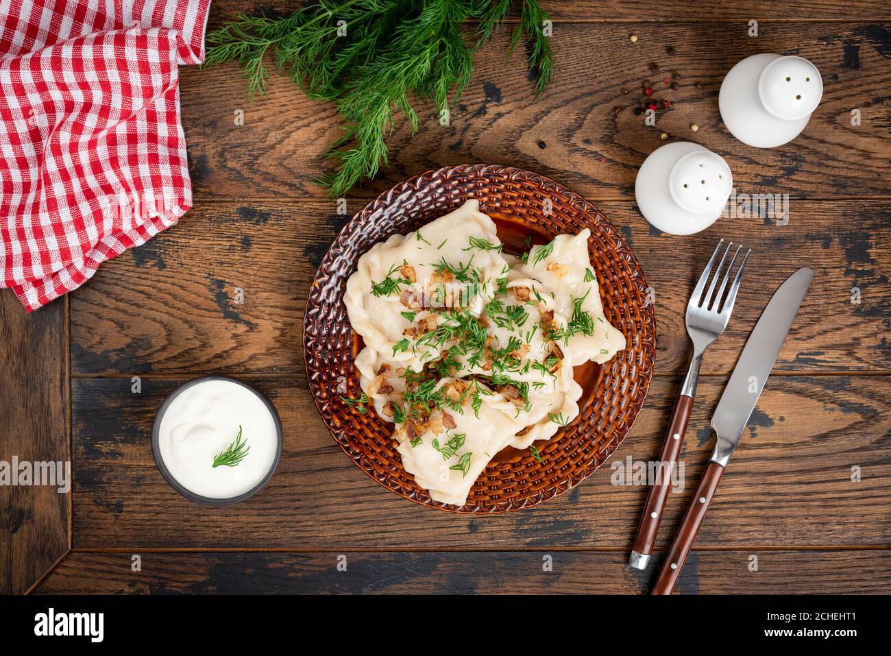 Polnischer Pierogi gefüllt mit Kartoffeln und garniert mit gebratener Zwiebel und Dill auf einem Teller. Gekochte Knödel, varenniki. Nationale Küche Stockfoto