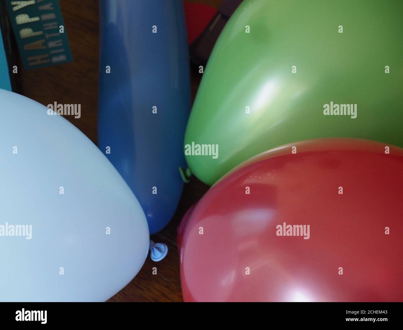 Rote, grüne und blaue Geburtstagsballons auf einem Tisch Stockfoto