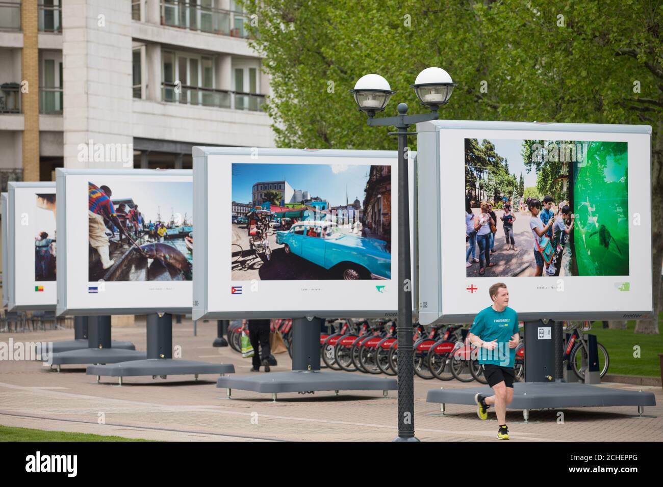 Beim britischen Debüt der Fotoausstellung Streets of the World in Canary Wharf, London, sehen sich die Mitglieder des Publikums Bilder von Hauptstädten aus der ganzen Welt vom Fotografen Jeroen Swolfs an. Stockfoto